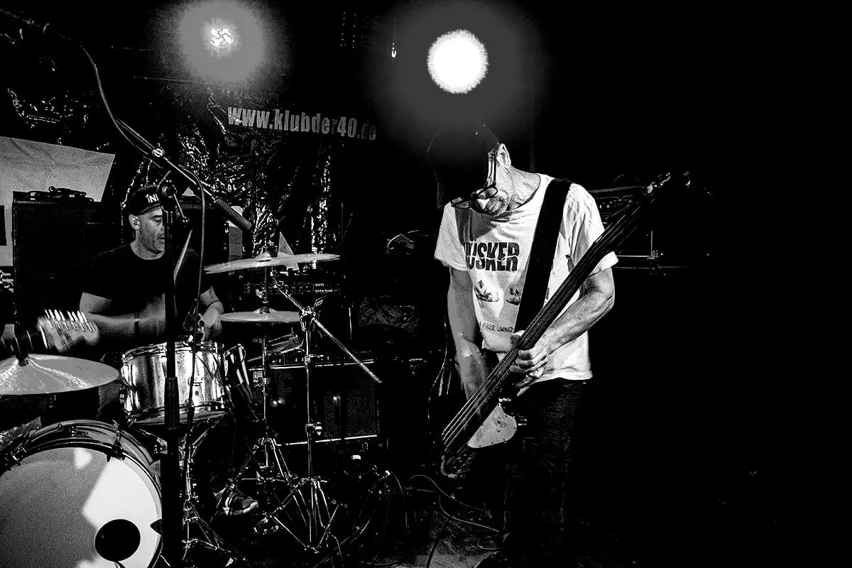 Bassist dissolving in blown-out backlight