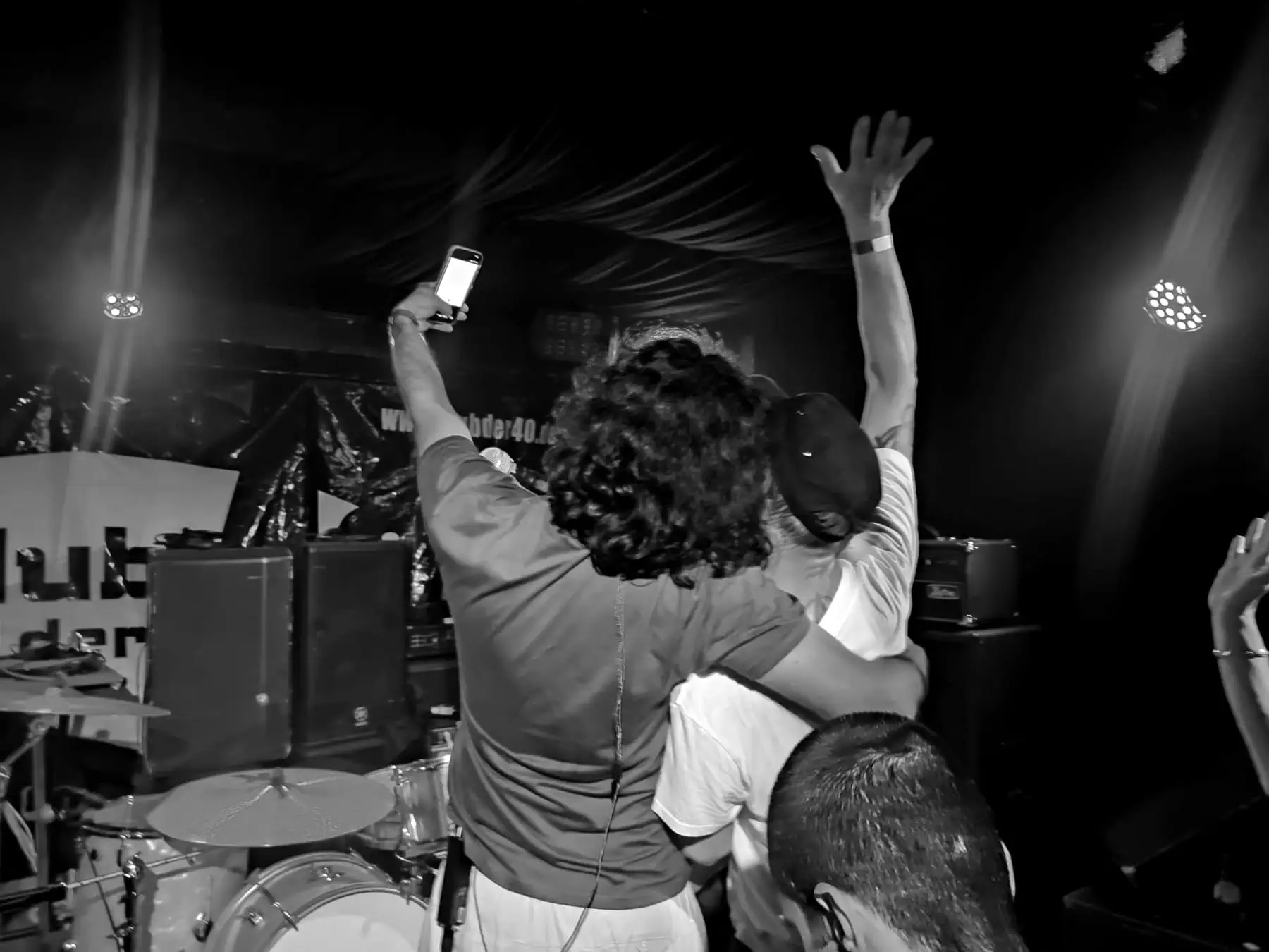 Two fans embracing in front of the stage