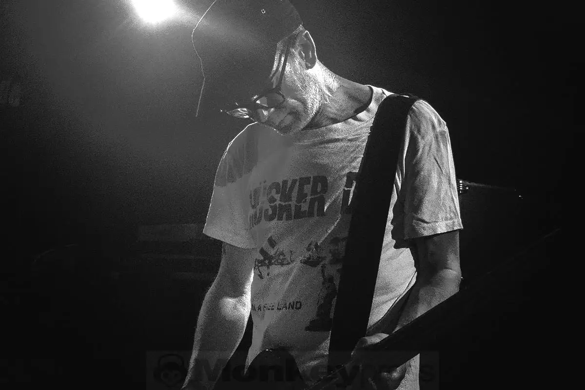 Guitarist in hard backlight, silhouetted by haze