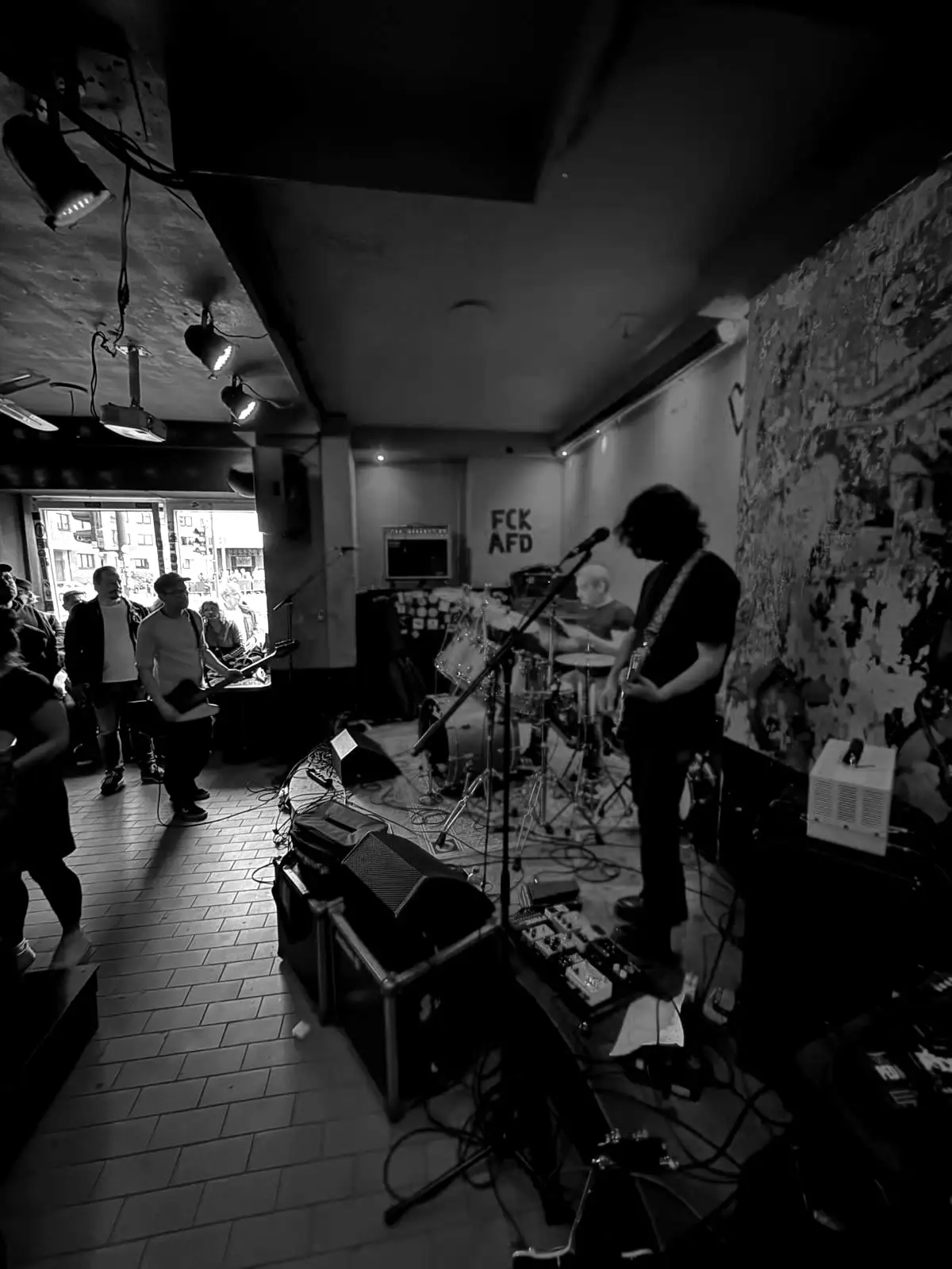Wide view of a packed pub show, cables and gear everywhere