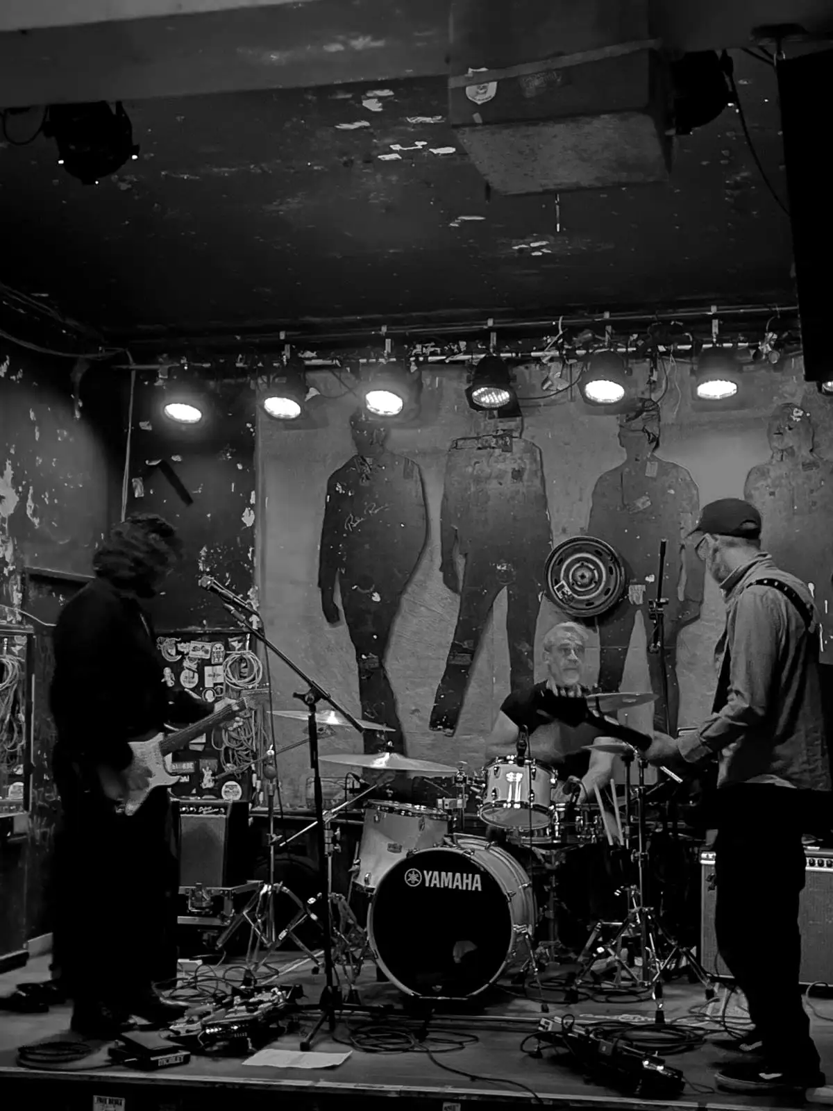 The band in front of a wall of painted silhouettes